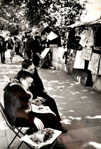 Untitled (Man and Woman Seated on Chairs Shelling Peas and Newsstands along the Sidewalk, along the Seine)