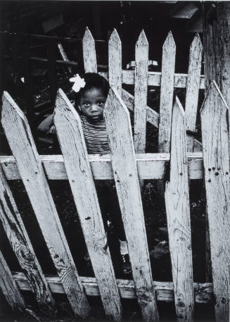 Untitled, Chicago (Little girl with bow in hair, standing behind picket fence)
