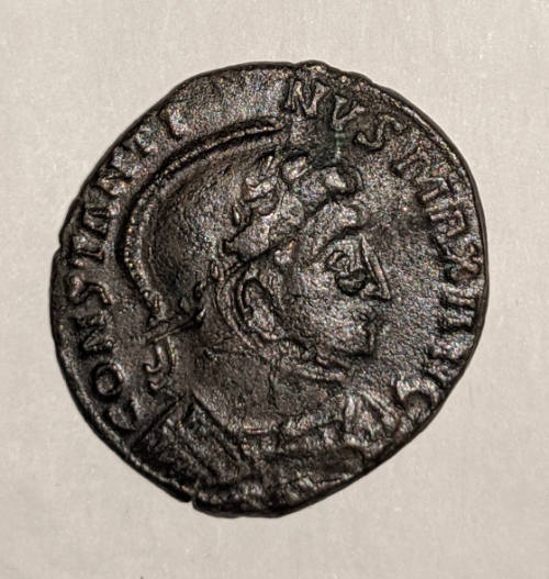 Coin of Flacus Valerius Constantinus: Helmeted and Laureate Head of Constantine (obverse), Two Standing Victories Holding a Shield on an Altar (reverse)