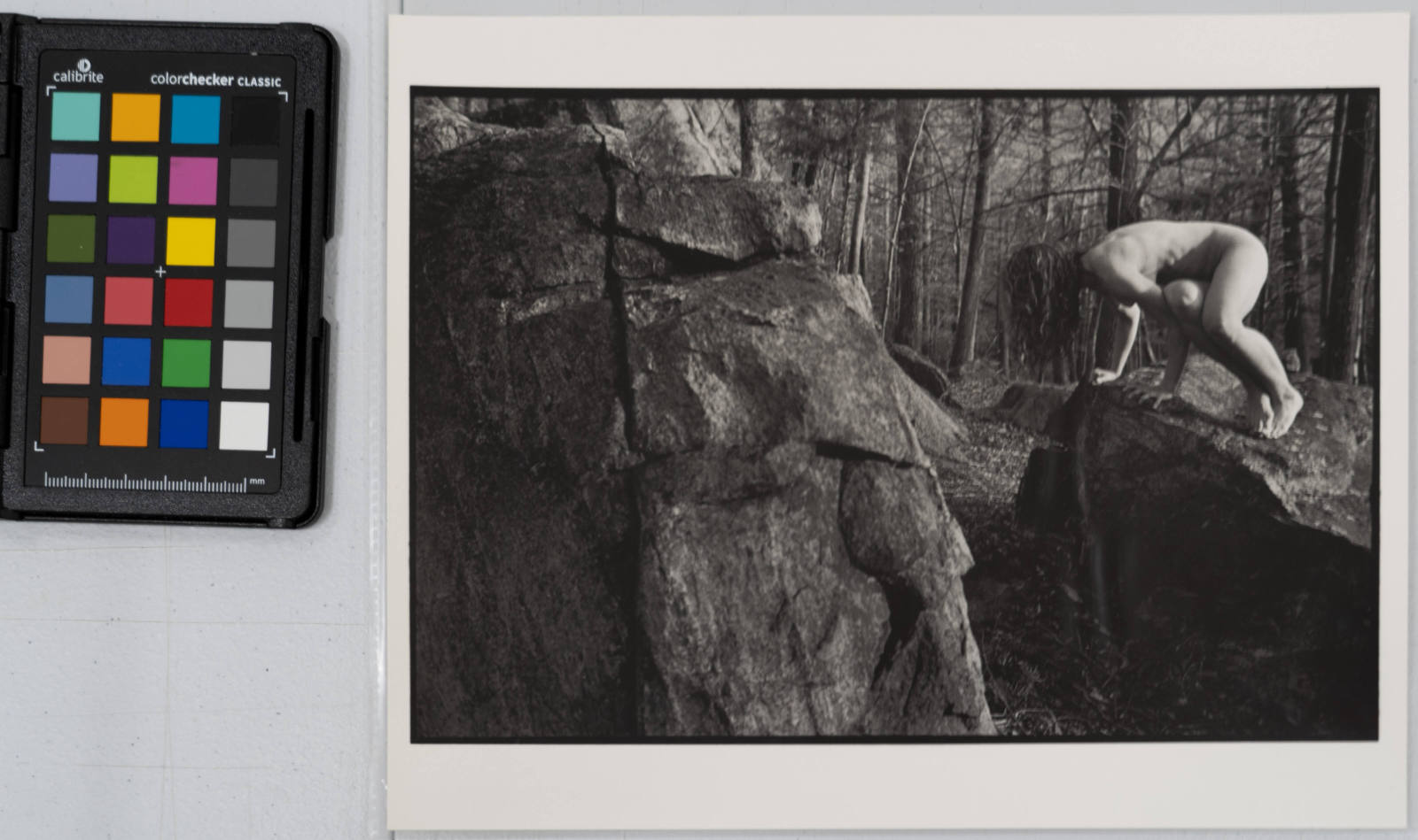 Kate, nude, inside crow pose on a rock in the forest