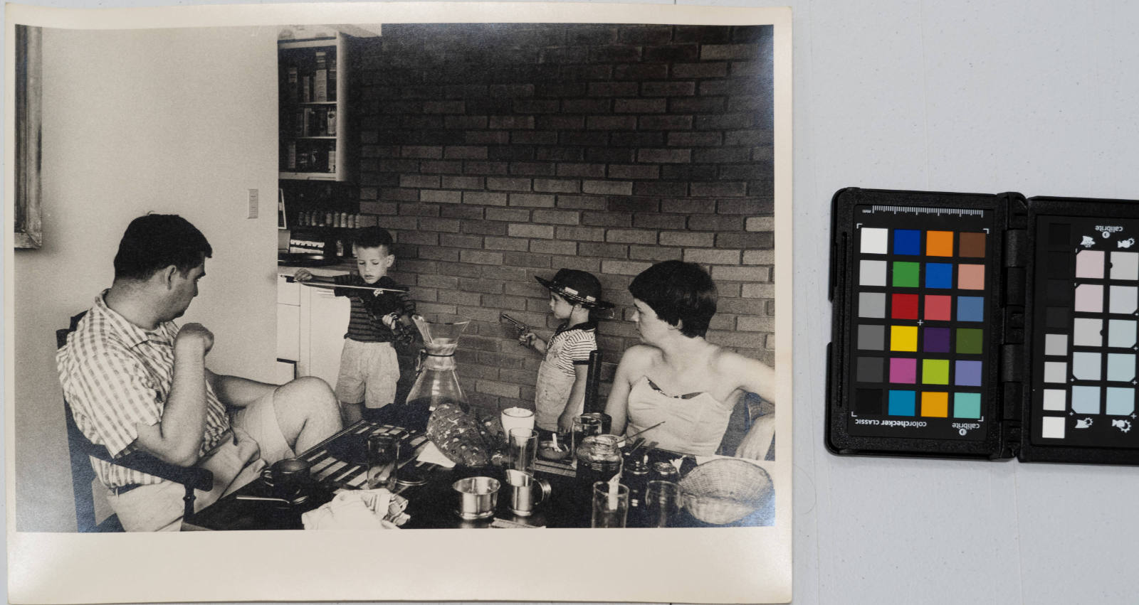 Pierre and Mrs. Salinger listen to their son playing violin, with younger son pointing toy gun