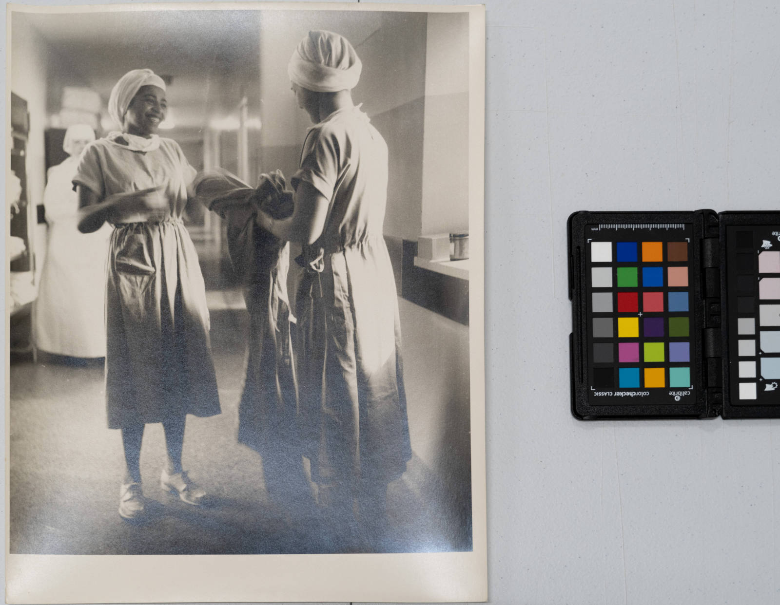 Negro Nurses - black nurse laughing with colleague while changing medical gown