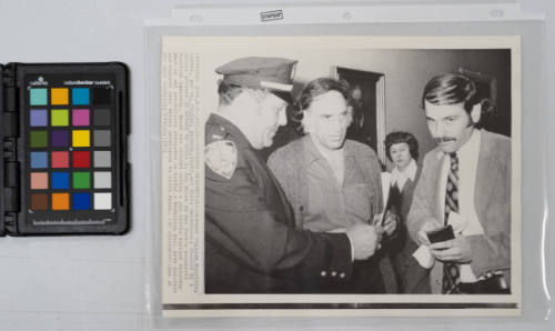 Checking Credentials: Lawyer William Kunstler, center, and Dr. Frankel Kenneth, right, get their credentials checked by a police officer in effort to visit H. Rap Brown in New York's Roosevelt Hospital Saturday. Brown was wounded during a gun battle earlier Saturday when he and accomplices attempted to holdup a Manhattan bar. Both Kunstler and Kenneth were denied permission to visit Brown, October 16, 1971