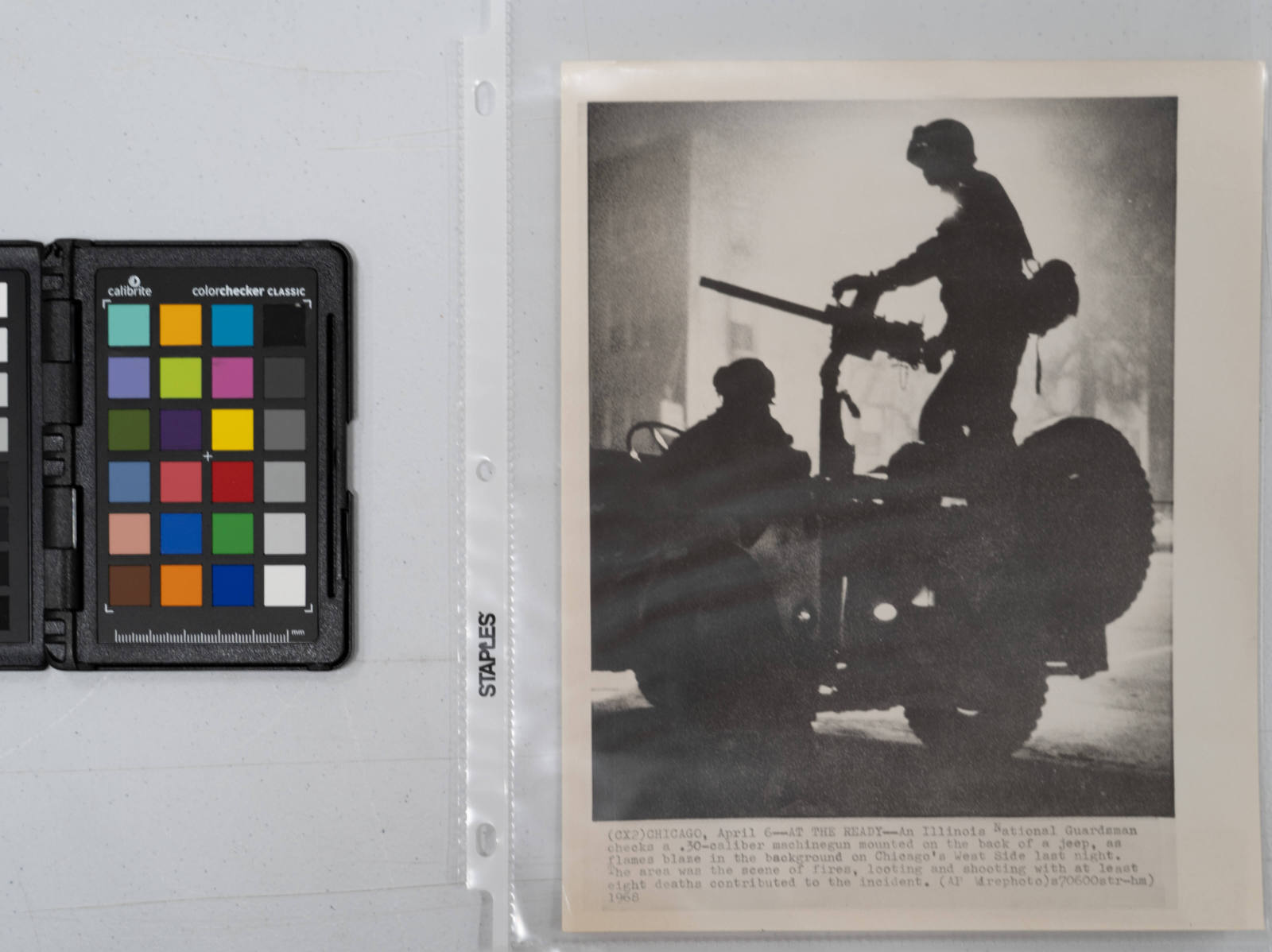 At The Ready: An Illinois national guardsman checked a machine gun mounted on the back of a jeep as flames shot up in the background on Chicago's west side Friday night. The area was the scene of fires, looting and shooting with at least eight deaths contributed to the incident. Three thousand troops patrolled the area, April 6, 1968