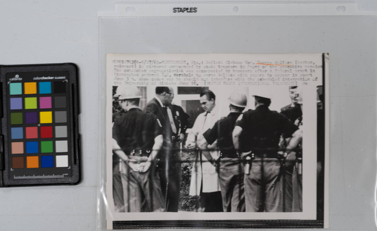 Defiant Alabama Governor George Wallace (center, raincoat) is pictured surrounded by state troopers in front of the executive mansion the outspoken segregationist was accompanied by troopers after a federal court in Birmingham ordered U.S. Marshals to serve Wallace with papers to appear in court June 3 to show cause why he should not interfere with the scheduled integration of the University of Alabama June 10, Montgomery, Alabama, May 27, 1963