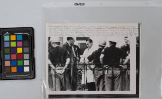 Defiant Alabama Governor George Wallace (center, raincoat) is pictured surrounded by state troopers in front of the executive mansion the outspoken segregationist was accompanied by troopers after a federal court in Birmingham ordered U.S. Marshals to serve Wallace with papers to appear in court June 3 to show cause why he should not interfere with the scheduled integration of the University of Alabama June 10, Montgomery, Alabama, May 27, 1963