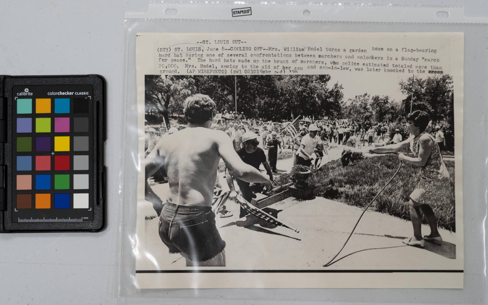 Cooling Off: Mrs. William Hodel turns a garden hose on a flag-bearing hard hat during one of several confrontations between marchers and onlookers in a Sunday "march for peace." The hard hats made up the brunt of marchers, who police estimated totaled more than 20,000. Mrs. Hodel, coming to the aid of her son and son-in-law, was later knocked to the ground, St. Louis, Missouri, June 8, 1970