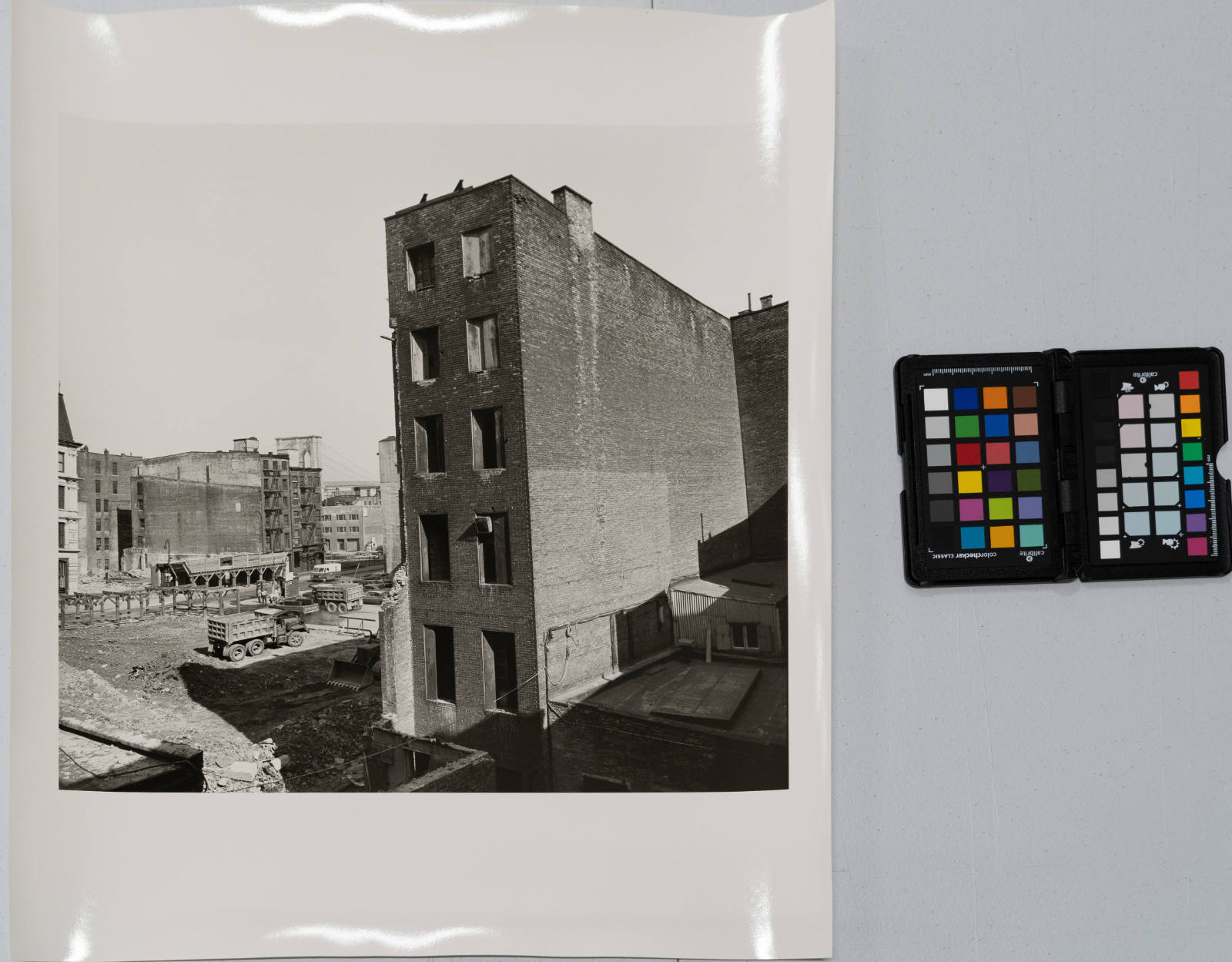 View of tall building next to empty lot with Brooklyn Bridge in background, from the Destruction of Lower Manhattan